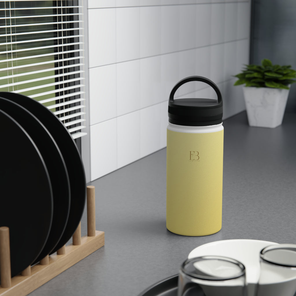 Insulated lemon yellow water bottle with black lid and handle in an indoor setting