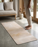 Beige yoga mat with subtle marbled swirls and black non-slip edge on floor