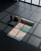 Natural rubber yoga mat with pastel pink and teal wave pattern, laid on tiled floor.