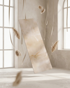Beige yoga mat hanging vertically with black edge and textured surface