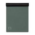 Rolled cypress green yoga mat with a dark cap at one end and logo mark.
