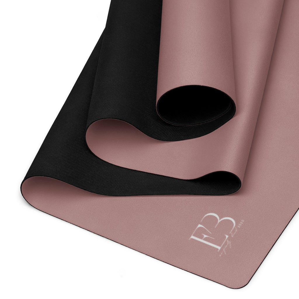 Rolled mauve yoga mat with black underside, top view of rolled edges.