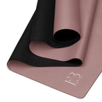 Rolled mauve yoga mat with black underside, top view of rolled edges.