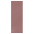 Clay mauve yoga mat with textured surface and logo mark at bottom.