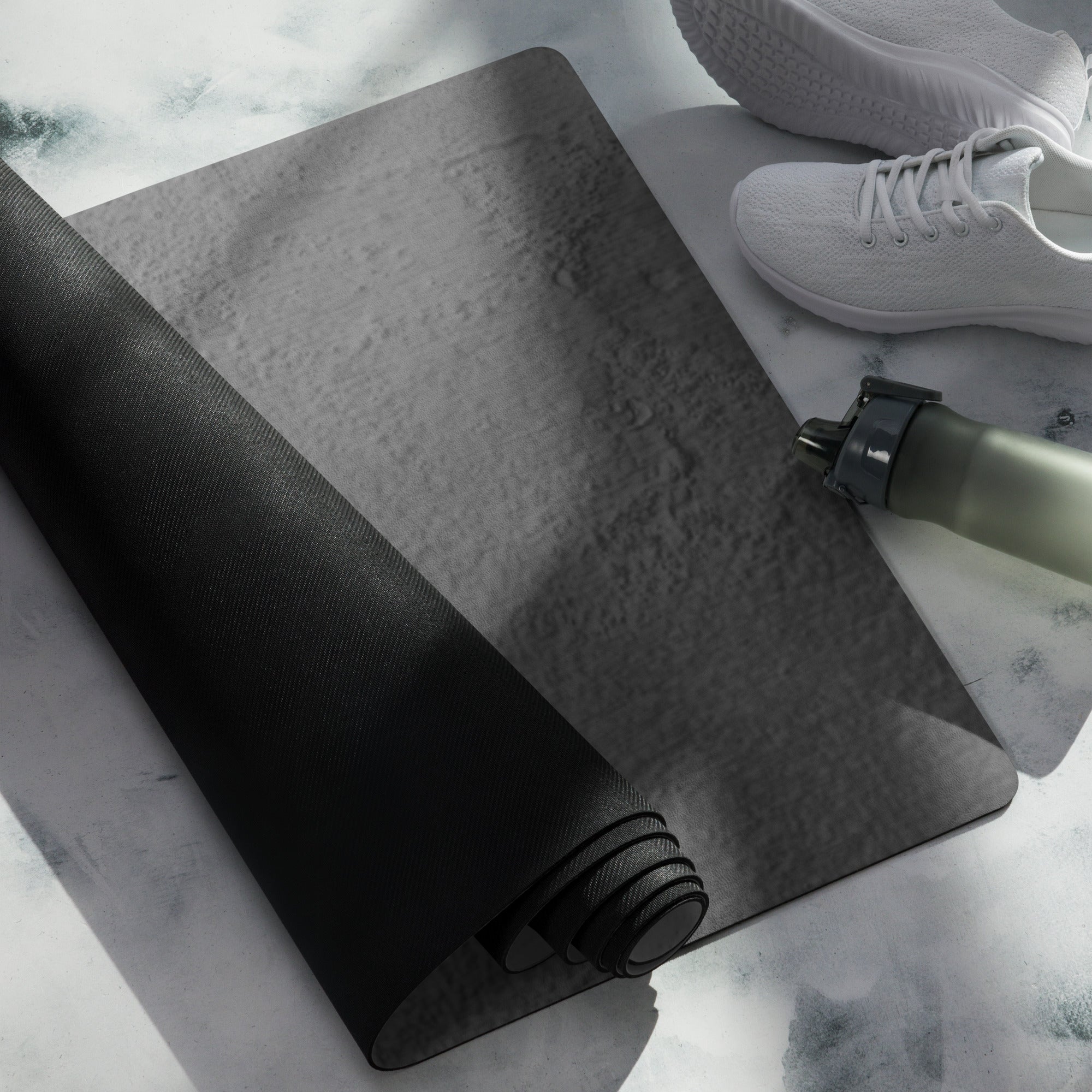 Dark gray yoga mat with rolled edge; sneakers and bottle nearby. Eco Black Dark gray natural rubber yoga mat with Suede top 