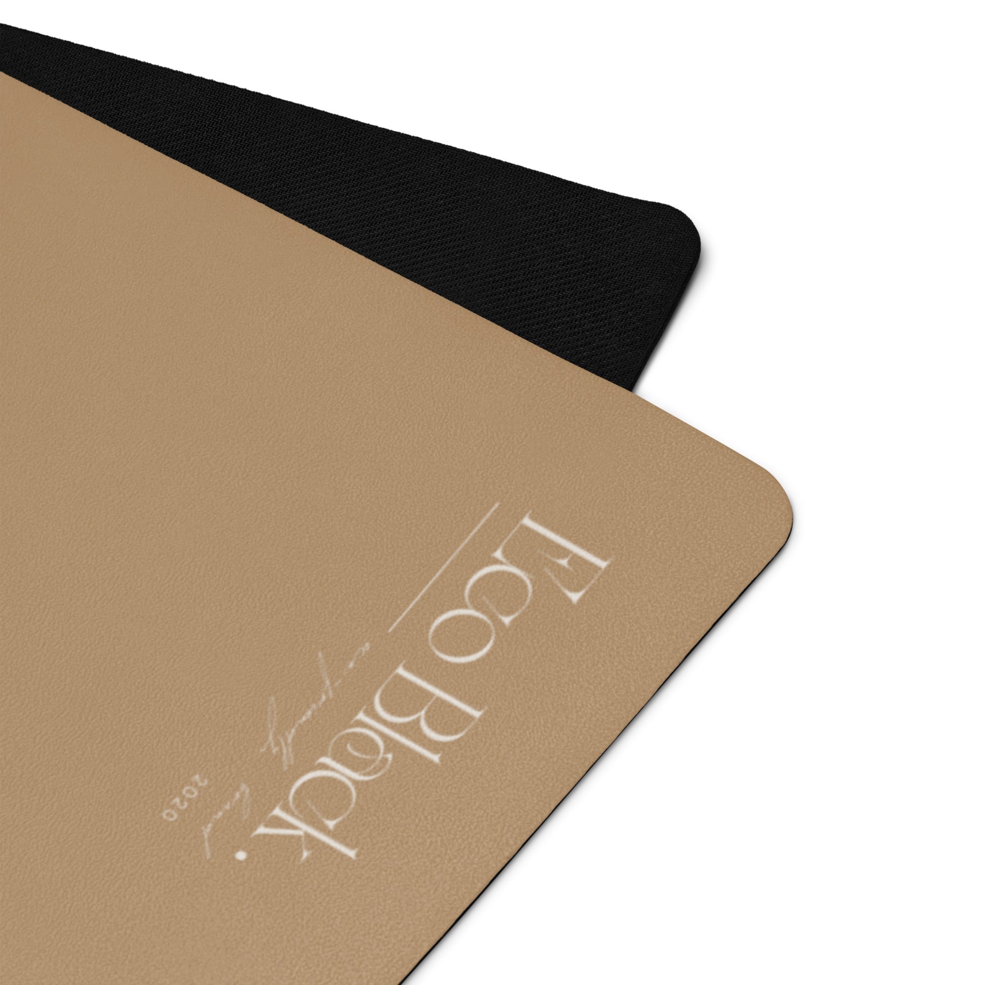 Natural rubber yoga mat corner with black edge trim and white logo.