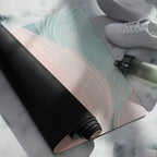 Yoga mat showing rolled black underside and pastel pink-teal swirl top surface