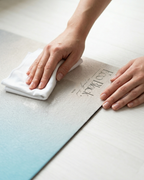 Light blue yoga mat surface being wiped with a folded cloth