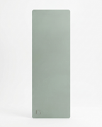 Light sage yoga mat front view with embossed logo at bottom