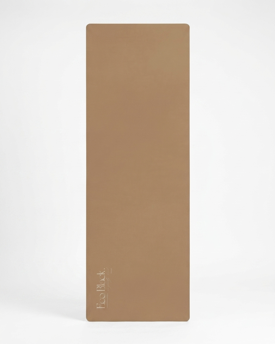 Taupe natural rubber yoga mat standing vertically with logo