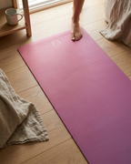 Rose Orchid natural rubber yoga mat in rose-pink on a wood floor with B3 logo visible.