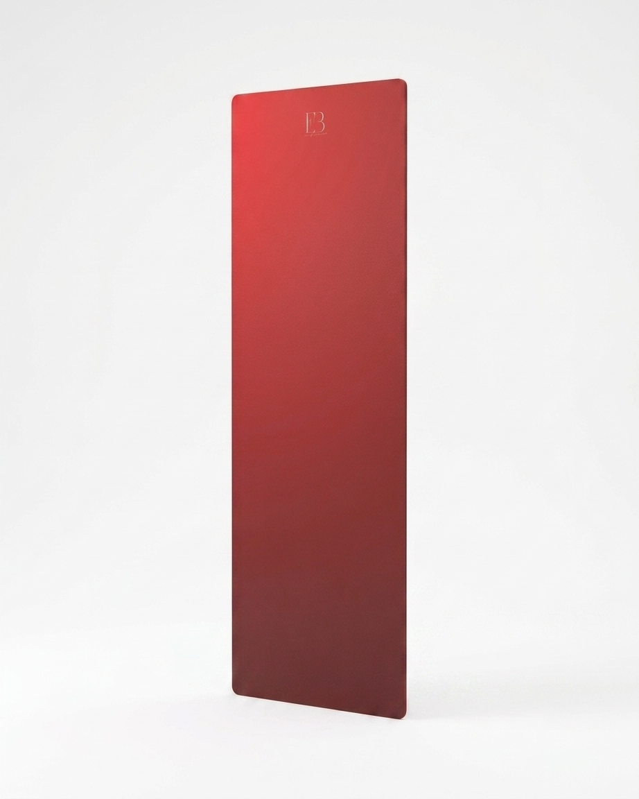 Red yoga mat with embossed logo, standing upright