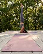 Natural rubber yoga mat with violet-pink horizon design, flat on a deck