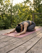 Rose Orchid natural rubber yoga mat in rose-pink, used for a floor yoga pose.