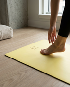 Lemon-yellow natural rubber yoga mat with small embossed logo