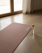 Chocolate brown natural rubber yoga mat, corner and edge with embossed logo.