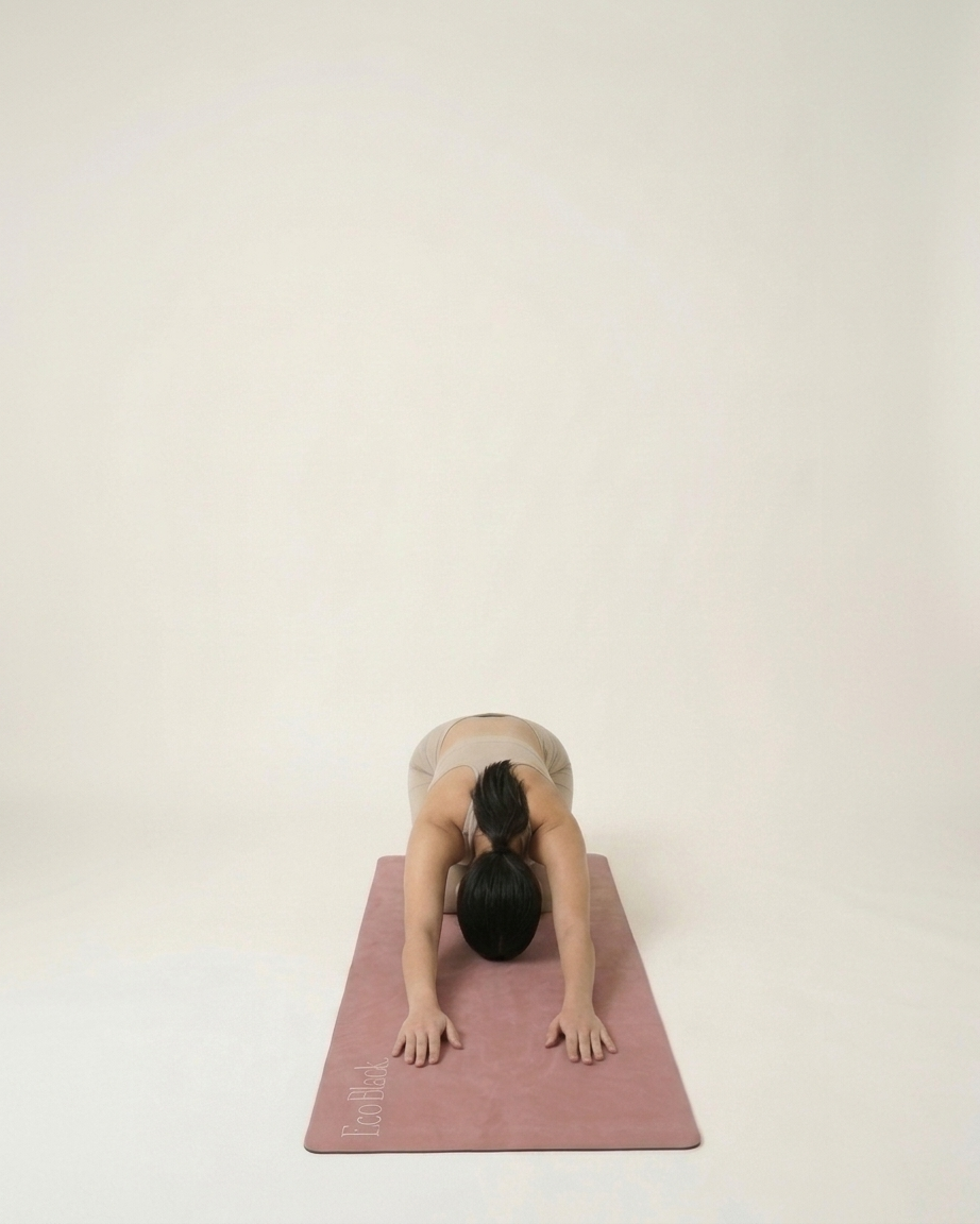 Natural rubber yoga mat in muted rose, with a person stretching on it