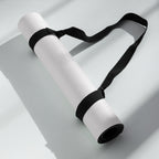 Light gray yoga mat secured with black carrying straps, rolled bundle