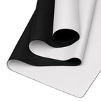 Dark yoga mat curled into a spiral on a light mat