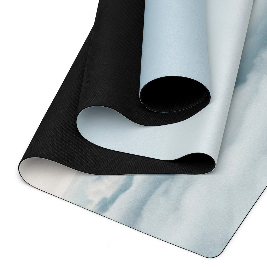 Natural rubber yoga mat showing black textured underside and light blue top