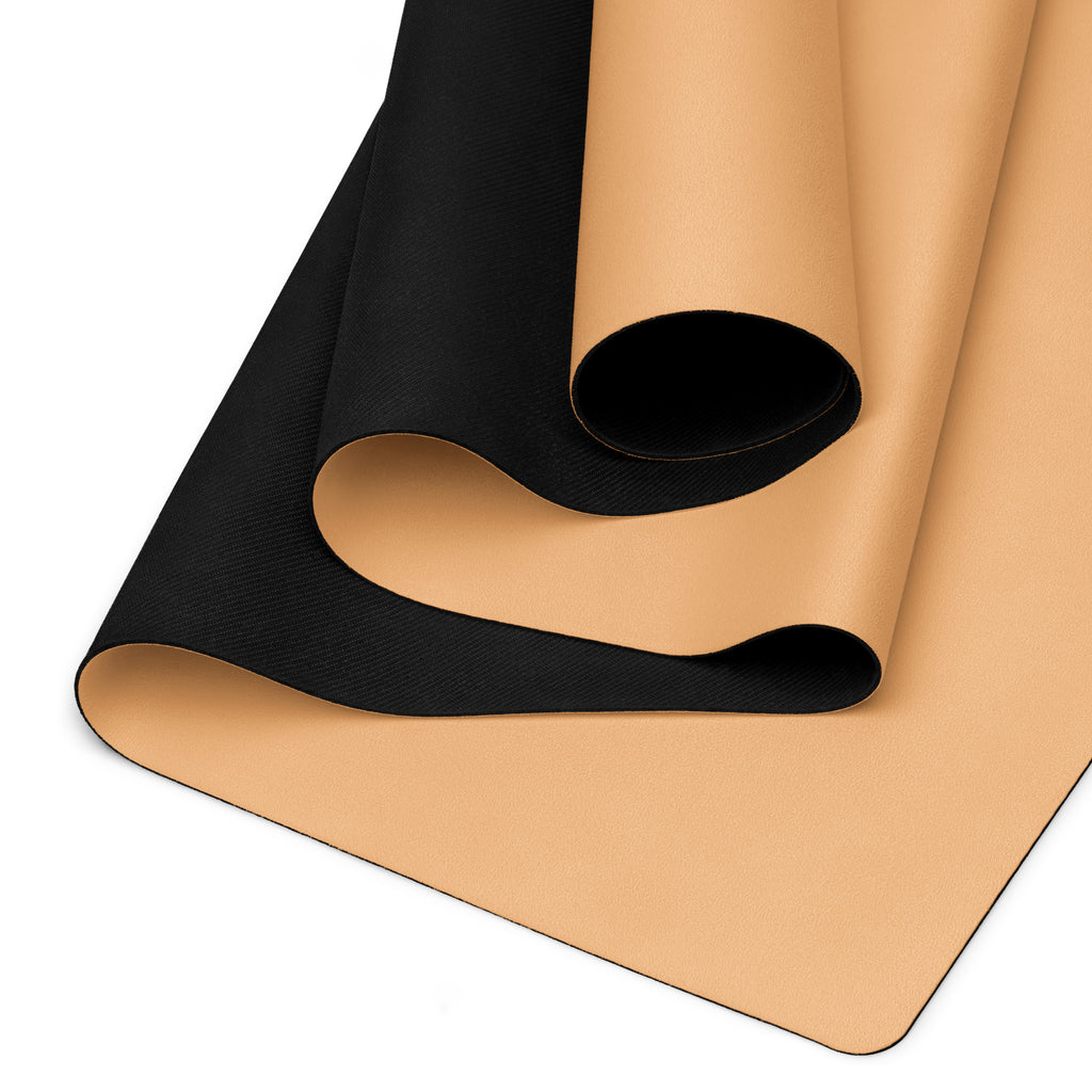 Close-up of golden yoga mat surface with black textured underside rolled