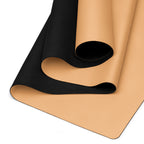 Close-up of golden yoga mat surface with black textured underside rolled