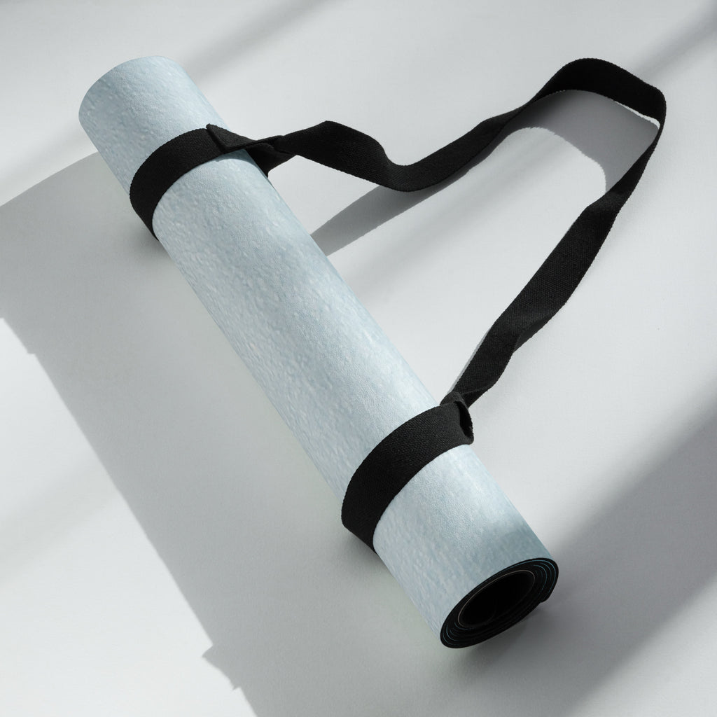 Light blue yoga mat rolled with black strap and coiled edges