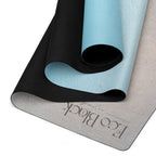 Rolled light blue yoga mat with black strap on a gray base layer