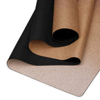 Rolled natural rubber yoga mat with black underside and brown top; close-up of edge.