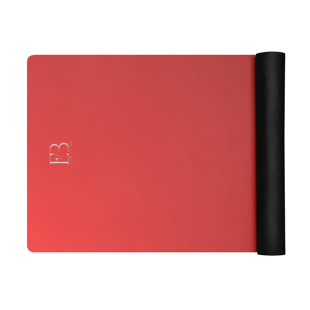 Crimson yoga mat with black rolled end, flat lay