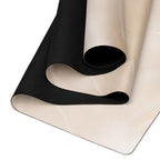 Beige yoga mat with black textured underside and rolled section