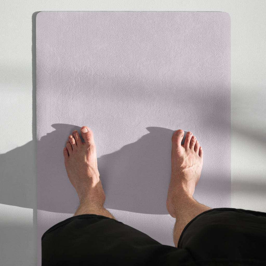 Lavender yoga mat in use for seated stretch with feet on the mat