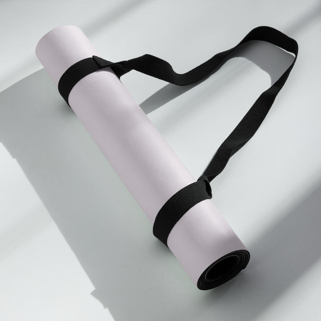 Lavender yoga mat with black carrying strap folded and tied
