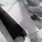 Lavender yoga mat unrolled with black underside and adjacent water bottle