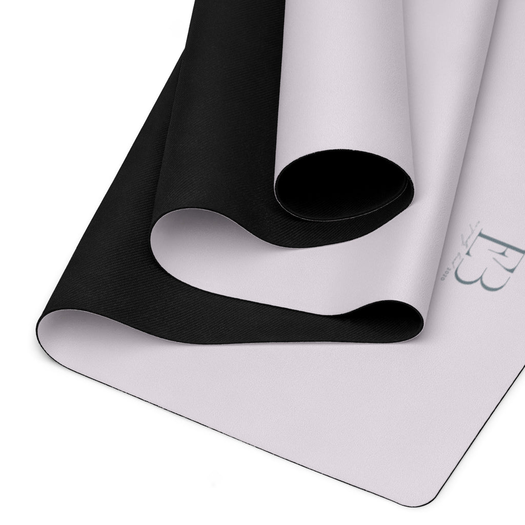Yoga mat showing rolled black underside and light top surface.