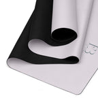 Yoga mat showing rolled black underside and light top surface.