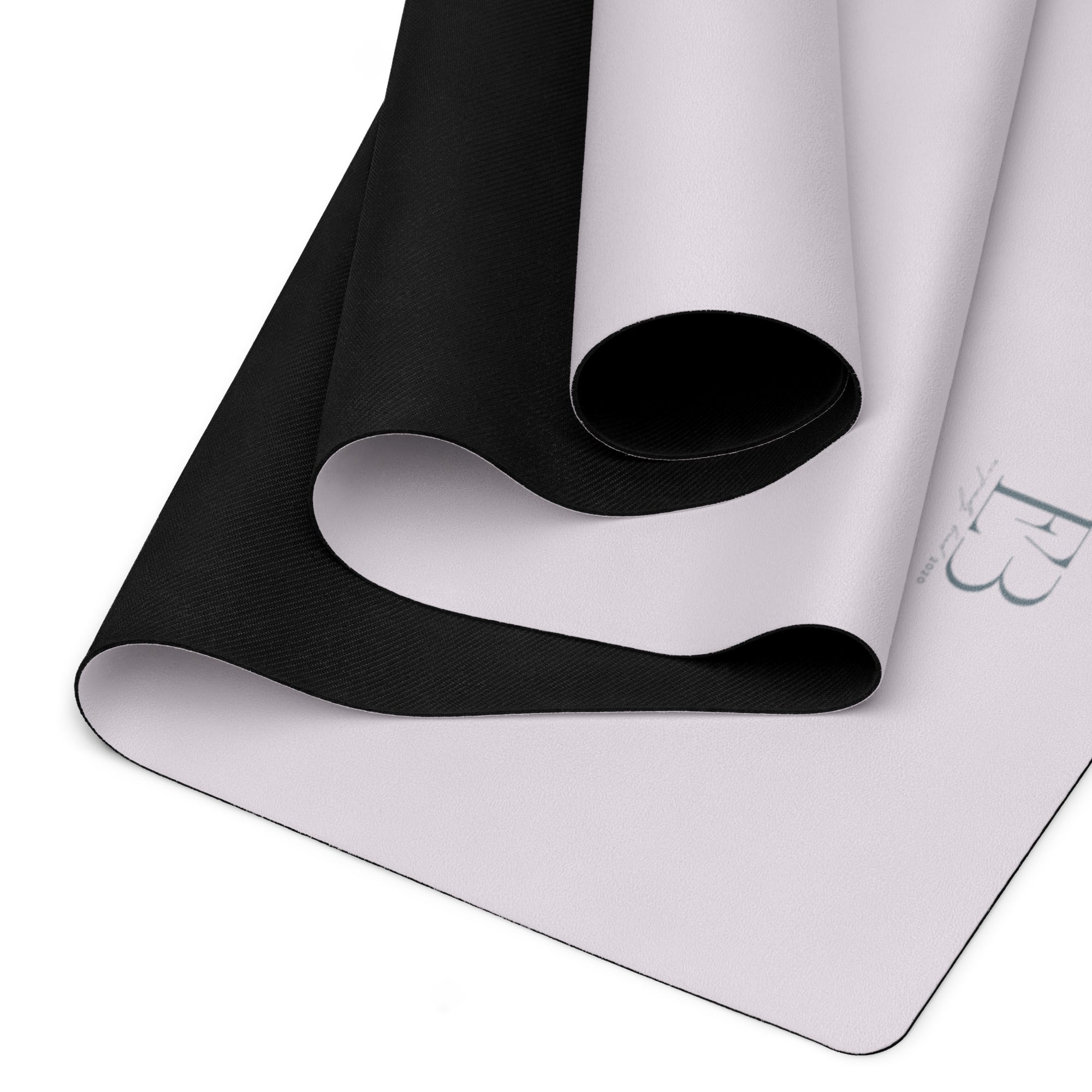 Yoga mat showing rolled black underside and light top surface.