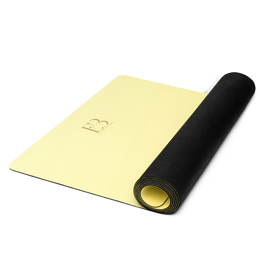 Yellow yoga mat rolled with black strap, viewed from above.