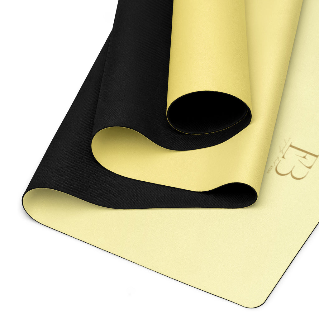 Yoga mat with textured black carrying strap and yellow natural rubber surface.