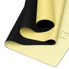 Yoga mat with textured black carrying strap and yellow natural rubber surface.