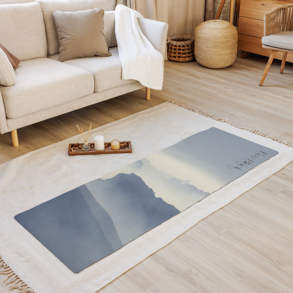 Yoga mat with blue mountain haze print laid on the floor in a living space.