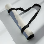 Rolled yoga mat with black carrying strap; blue mountain haze print showing.