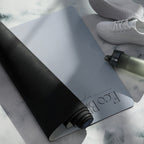 Natural rubber yoga mat in blue-gray, with dark textured underside and rolled end