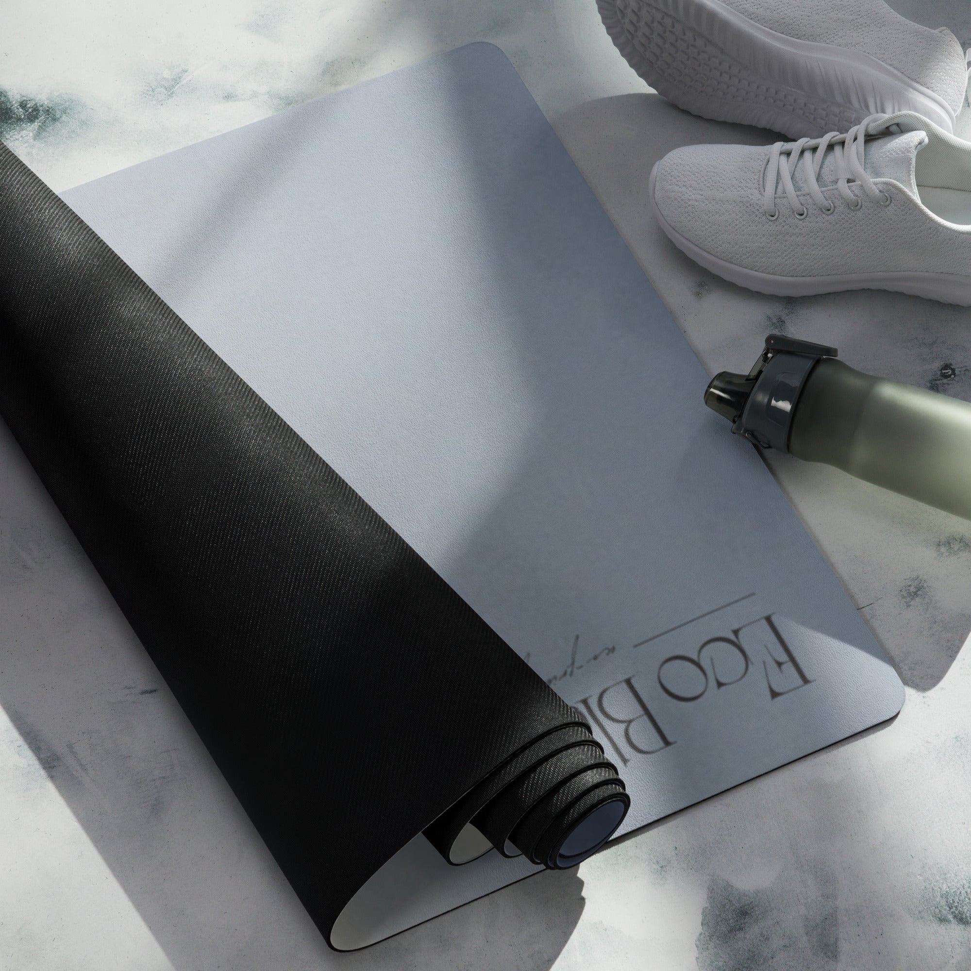Natural rubber yoga mat in blue-gray, with dark textured underside and rolled end