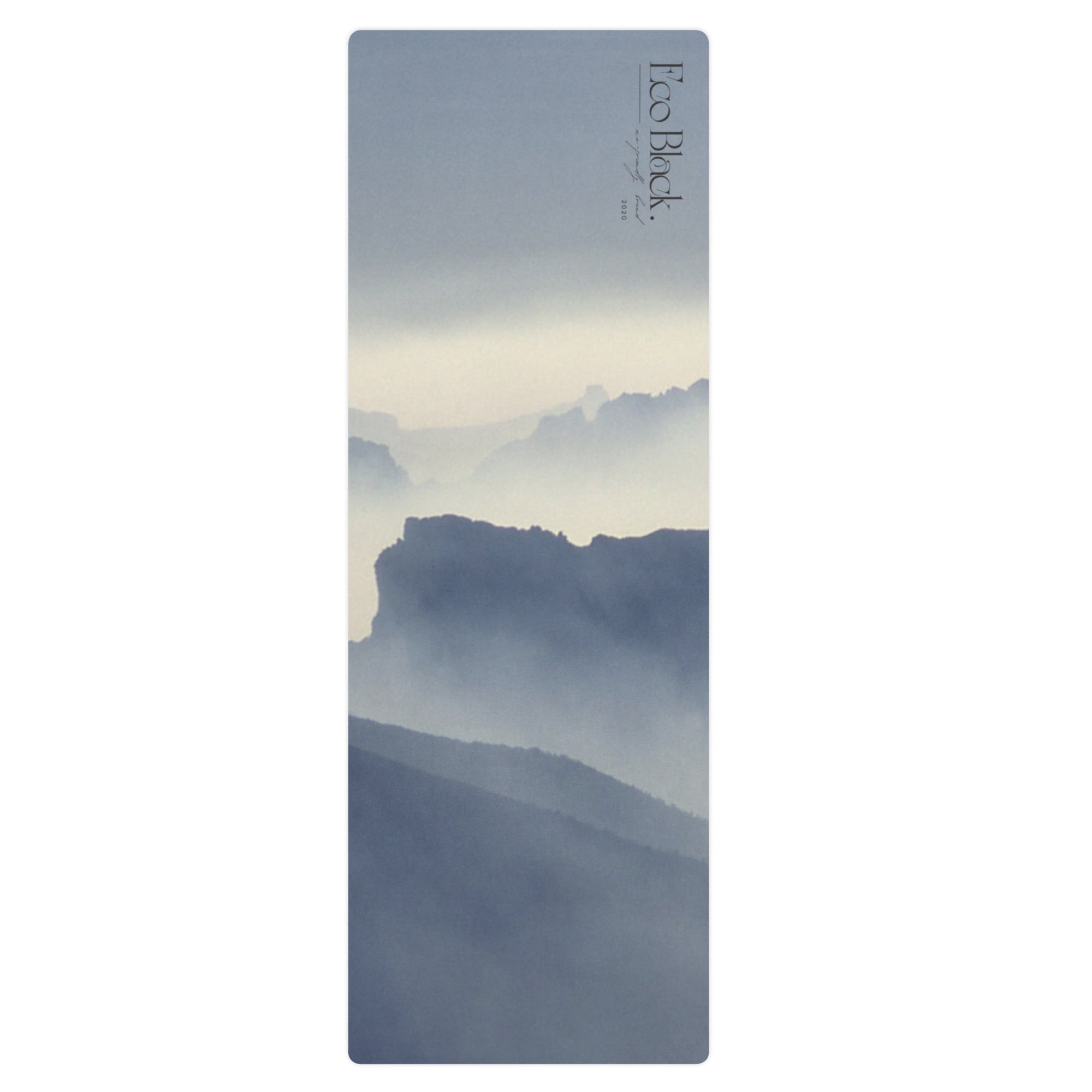 Yoga mat with blue mountain haze print on natural rubber; vertical branding label.