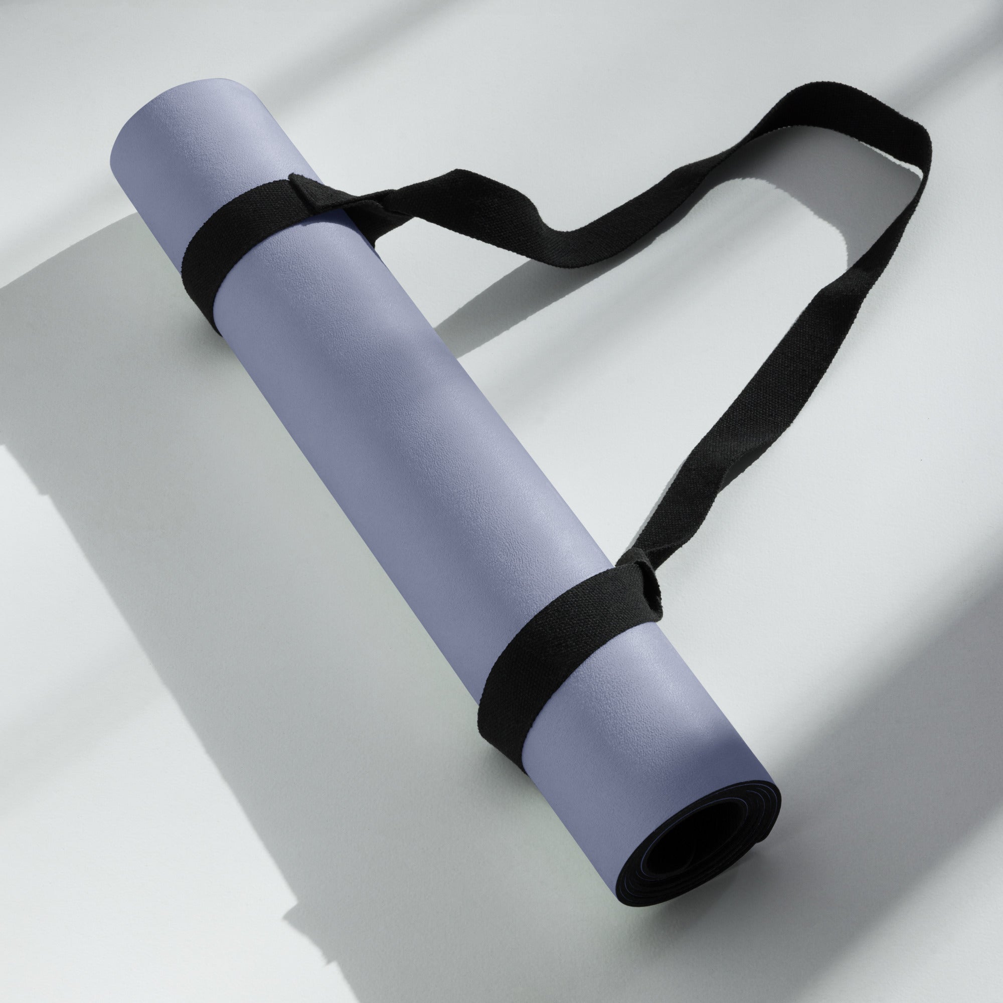 Pale iris natural rubber yoga mat rolled and secured with black straps
