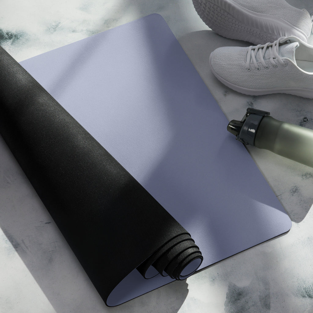 Pale iris yoga mat partially unrolled with black textured underside and rolled edge.