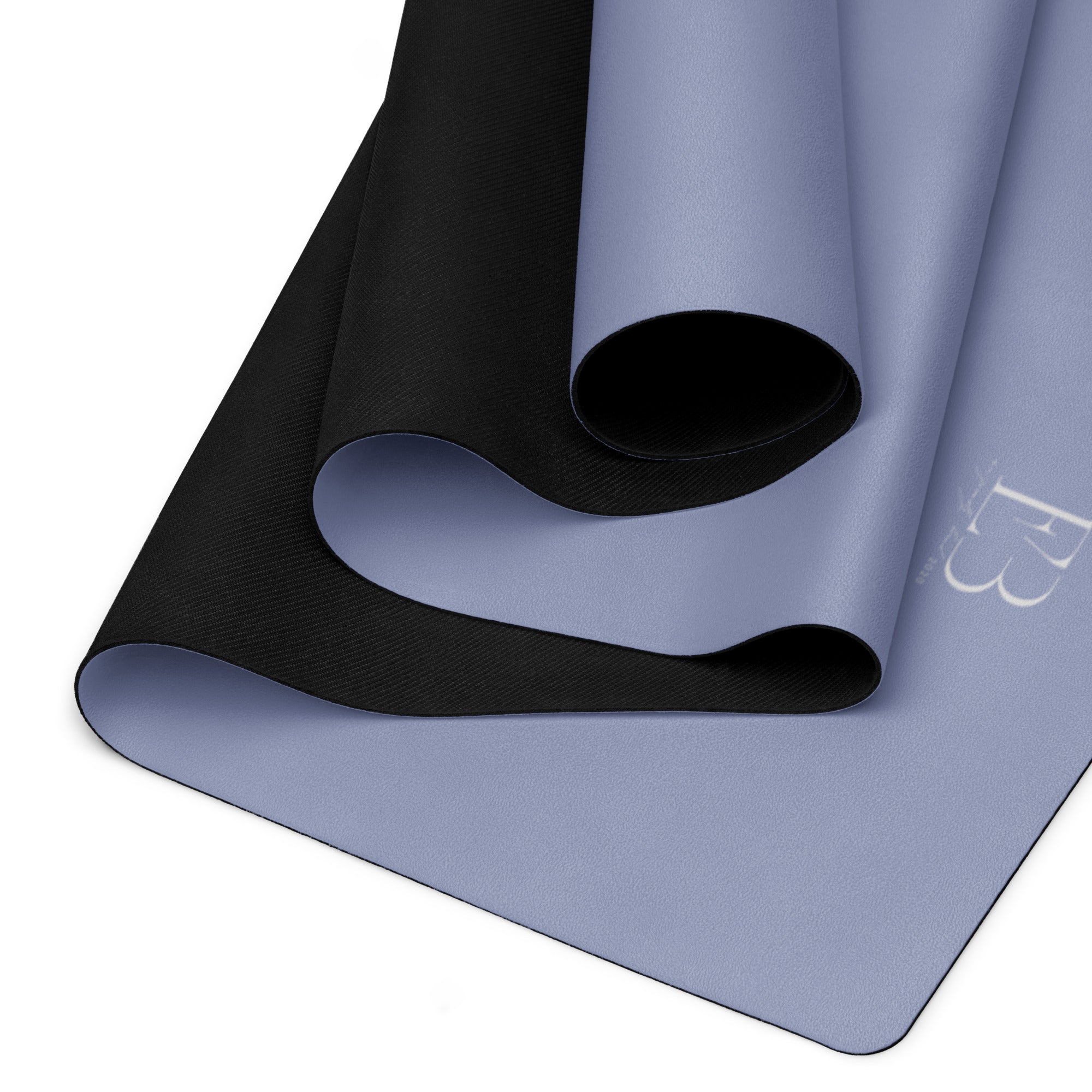 Pale iris yoga mat folded, showing black textured outer layer and rolled center.