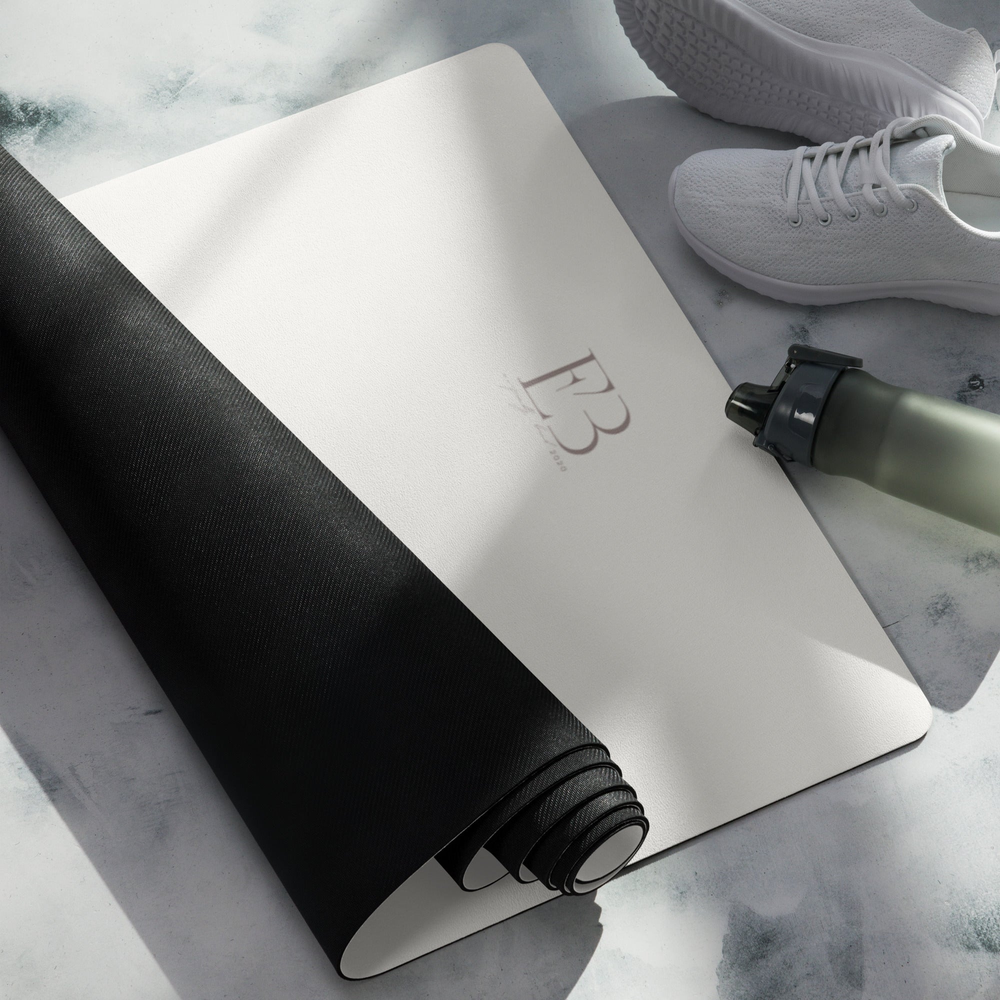 Vanilla cream yoga mat with black strap, paired with a rolled-up mat
