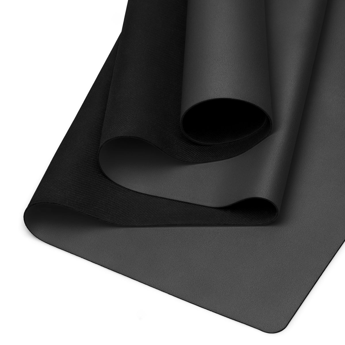 Black yoga mat detail with textured grip surface and rolled edge visible at corner.